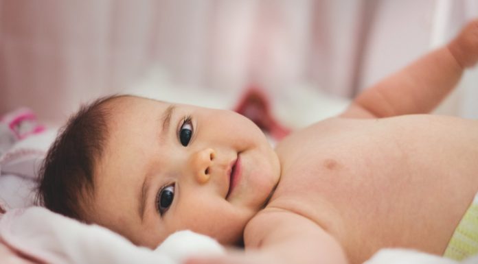 baby lying on pink bed