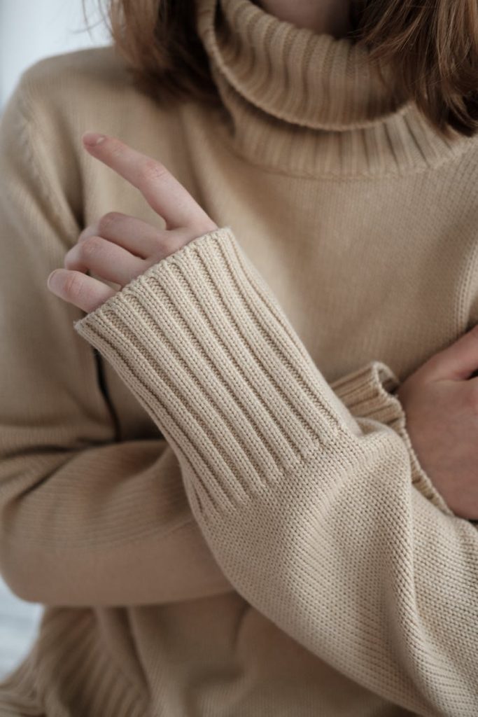 woman in sweater crossing arms on chest
