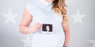 woman wearing white cap sleeved dress holding ultrasound result photo
