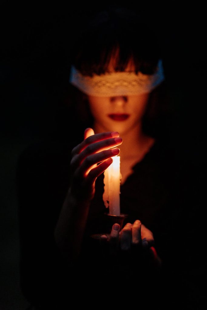 blindfolded woman with a lit candle