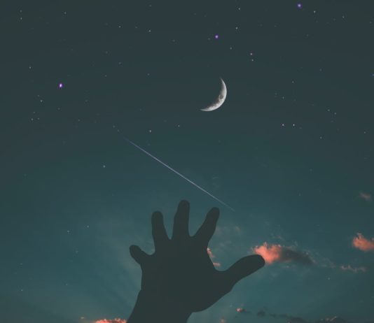 person hand and crescent moon