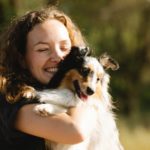 portrait of a happy woman hugging a dog