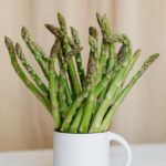 bouquet of fresh green stems in mug on table