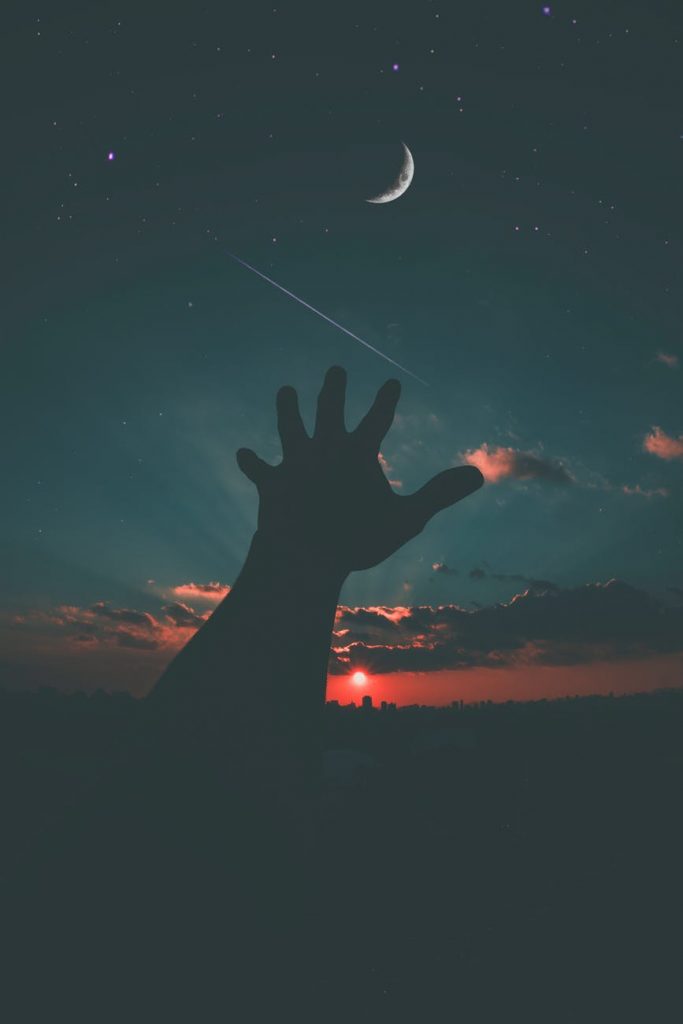 person hand and crescent moon
