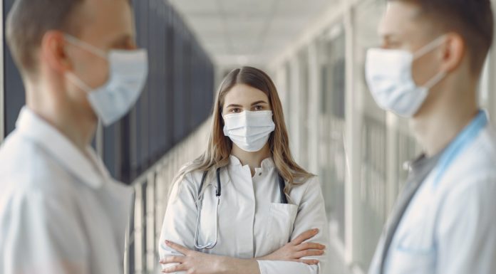 woman in white coat wearing white face mask