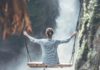 woman riding big swing in front of waterfalls