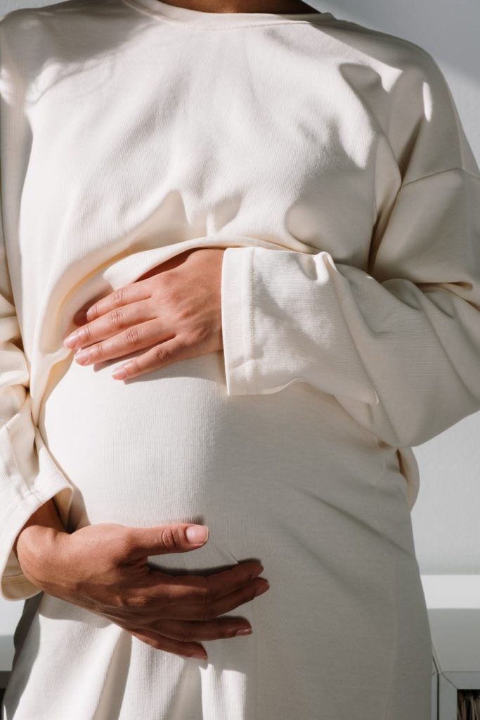 pregnant woman in white long sleeve dress