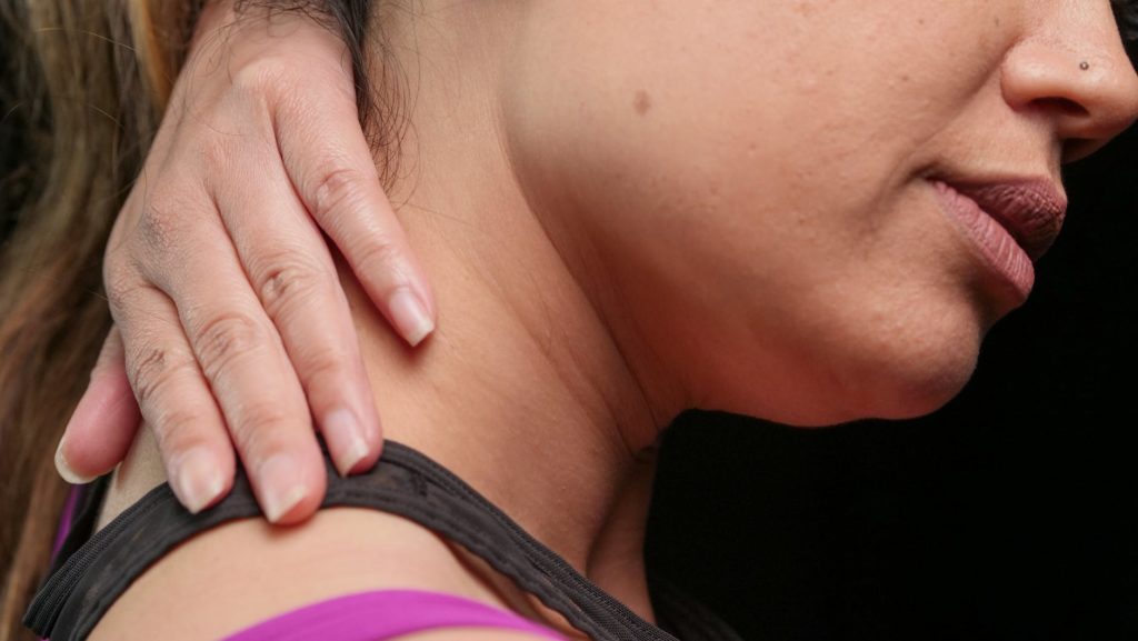 close up photo of a woman having a neck pain